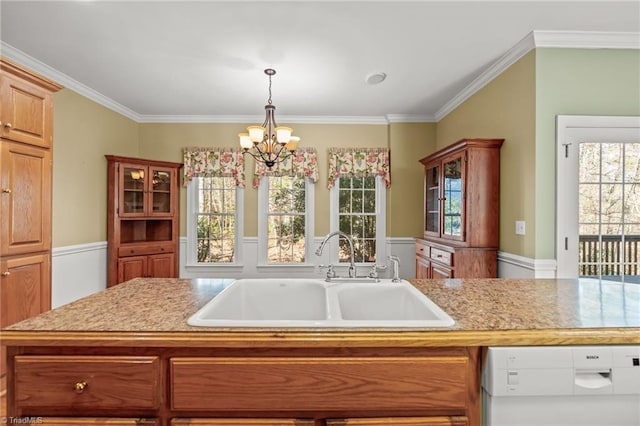 kitchen with decorative light fixtures, light countertops, an inviting chandelier, a sink, and white dishwasher