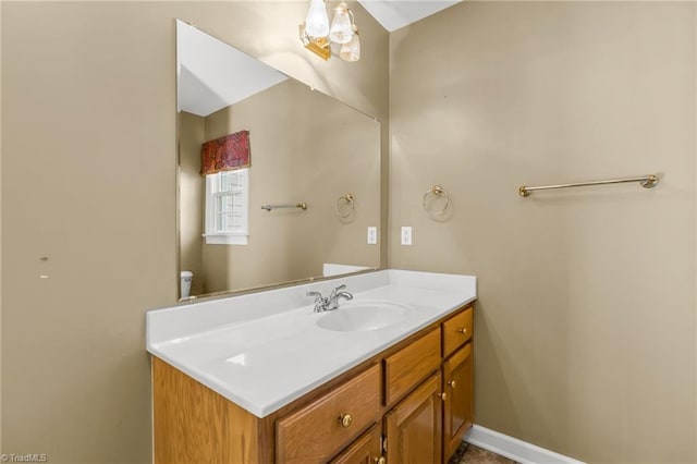 bathroom featuring toilet, vanity, and baseboards