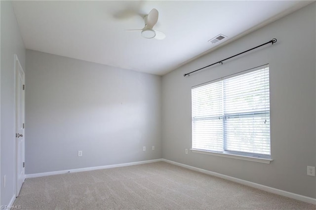empty room with a healthy amount of sunlight, baseboards, and light colored carpet