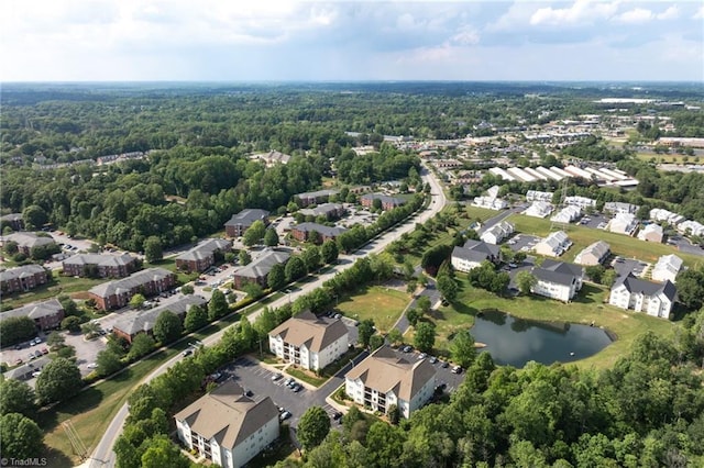 birds eye view of property featuring a water view, a view of trees, and a residential view