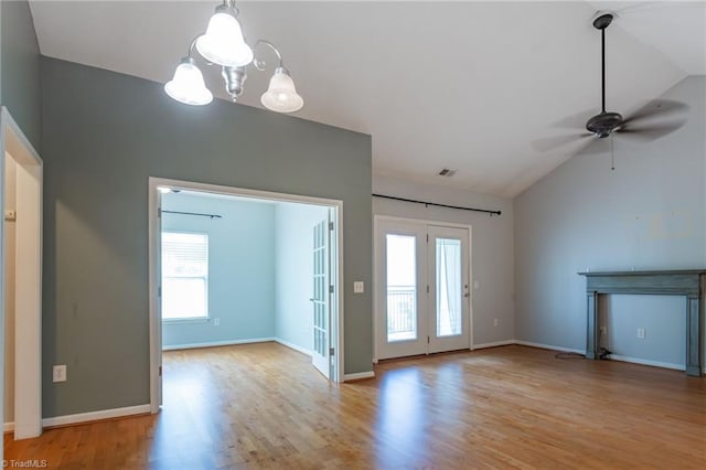 unfurnished living room featuring wood finished floors, plenty of natural light, and lofted ceiling