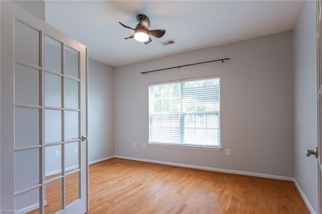 spare room featuring ceiling fan, baseboards, visible vents, and light wood-style flooring