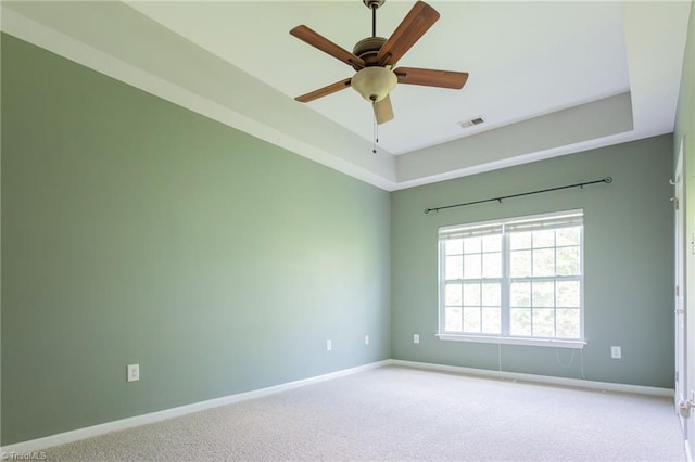 unfurnished room featuring carpet floors, baseboards, visible vents, and ceiling fan
