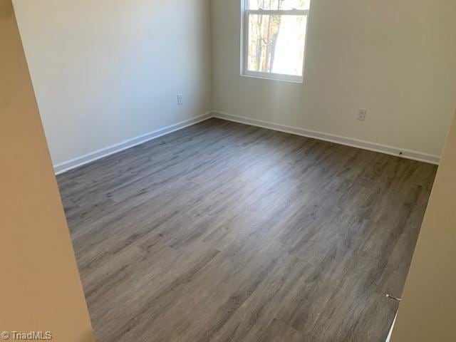 spare room with dark hardwood / wood-style flooring