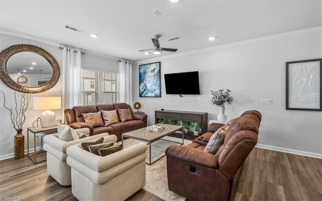 living room with hardwood / wood-style flooring, ceiling fan, and crown molding