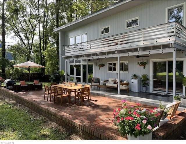 rear view of house featuring a balcony, an outdoor living space, a patio, and outdoor dining area