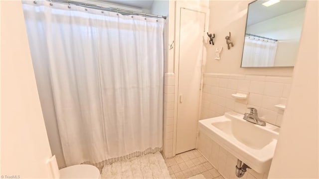 3307 Gaston Rd, Greensboro, NC 27407 - full bathroom with tile patterned floors, tile walls, a sink, curtained shower, and toilet