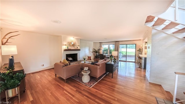 3307 Gaston Rd, Greensboro, NC 27407 - living area with a fireplace, light wood-style flooring, stairway, and baseboards