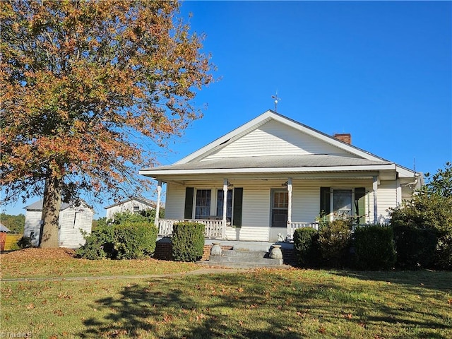 bungalow-style house with a front yard and covered porch