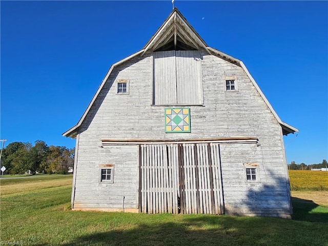 rear view of property with a yard and an outdoor structure