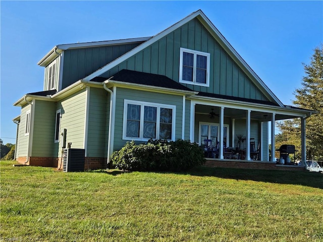 back of property featuring central AC unit and a yard