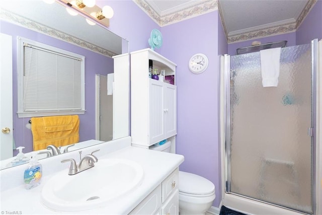 full bathroom with vanity, ornamental molding, a shower stall, and toilet