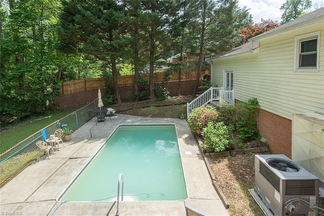 view of swimming pool with a fenced backyard, a fenced in pool, central AC unit, and a patio