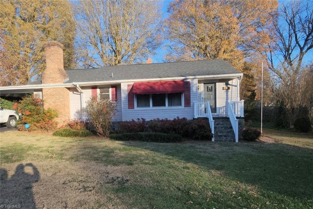 view of front of house with a front lawn and a carport