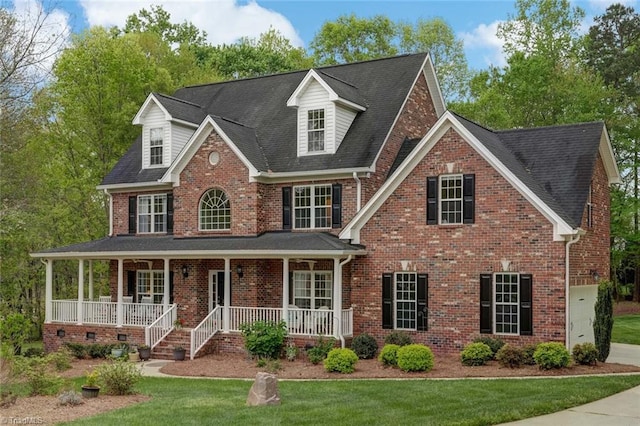 view of front of home featuring covered porch, brick siding, a front yard, and roof with shingles