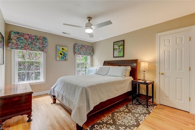 bedroom with visible vents, baseboards, ceiling fan, and wood finished floors