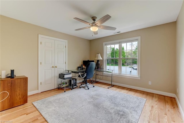 home office with baseboards, ceiling fan, wood finished floors, and visible vents