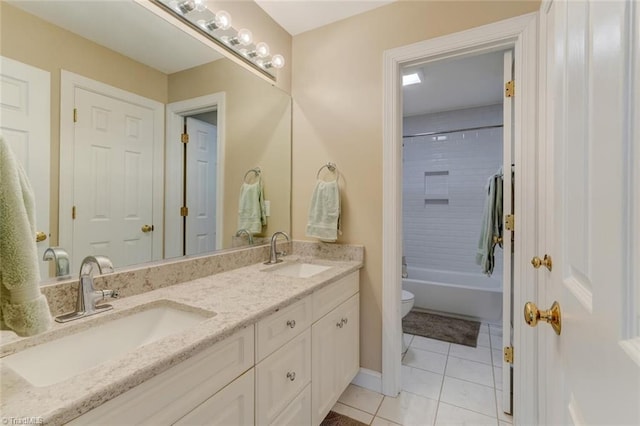 bathroom with toilet, double vanity, tile patterned floors, and a sink