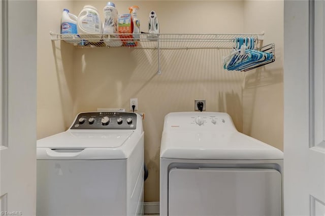 clothes washing area with separate washer and dryer and laundry area