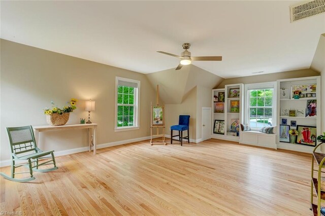 interior space with ceiling fan, visible vents, a healthy amount of sunlight, and wood finished floors