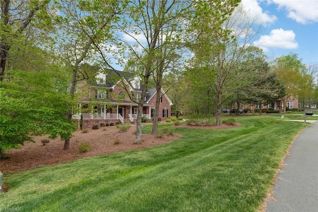 view of front of home with a porch and a front yard
