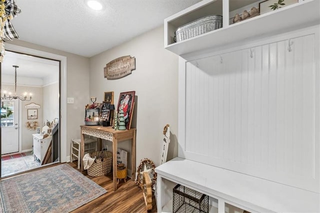 mudroom featuring dark hardwood / wood-style flooring, a textured ceiling, and a notable chandelier