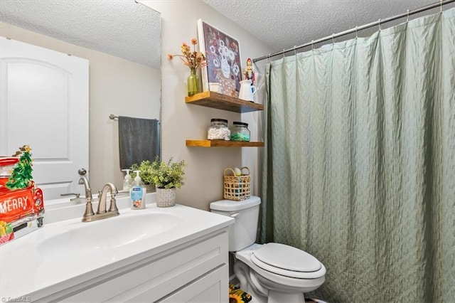 bathroom with vanity, a textured ceiling, toilet, and walk in shower