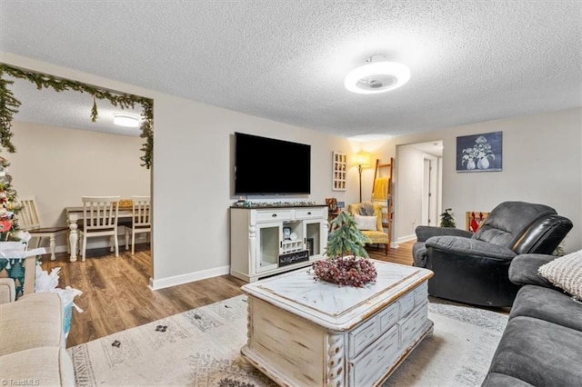 living room featuring light wood-type flooring and a textured ceiling