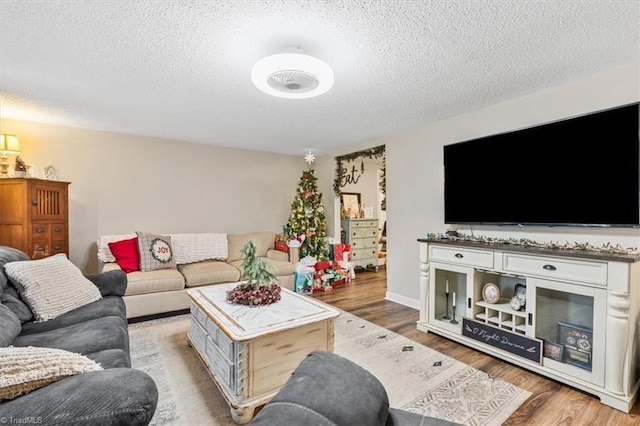 living room with a textured ceiling and light wood-type flooring