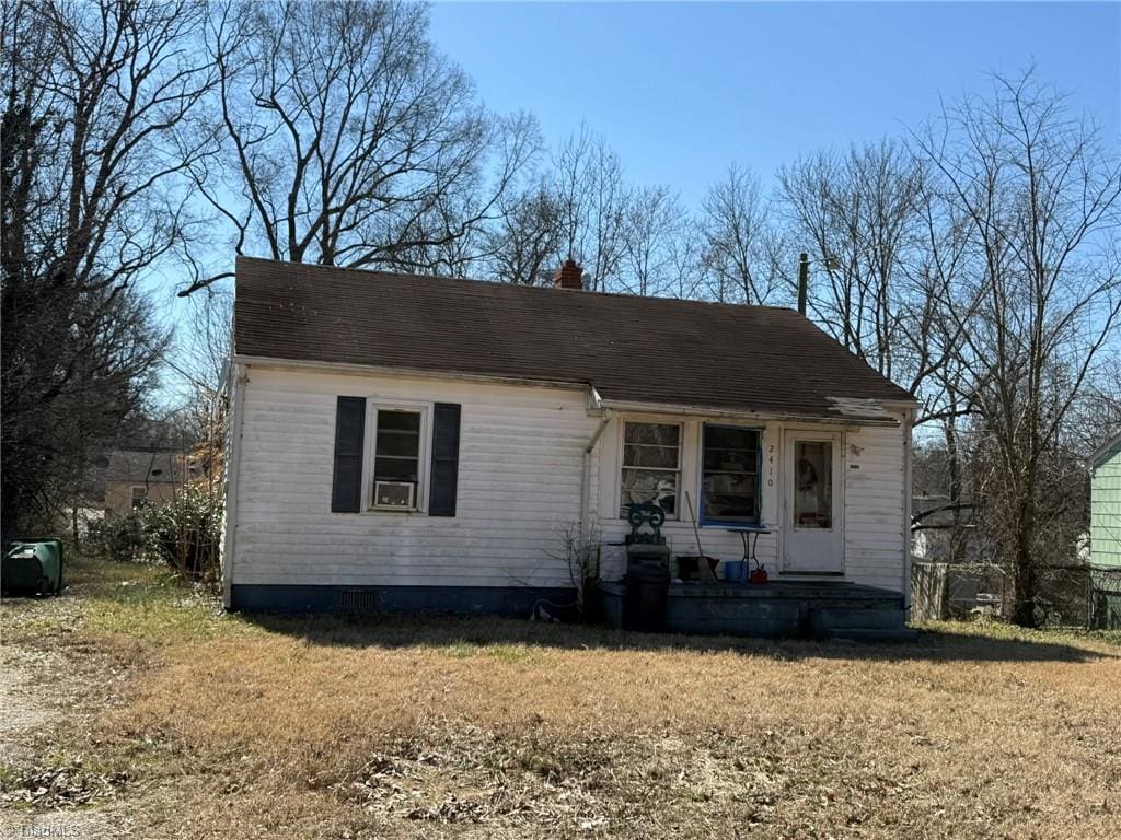 view of front of house with a chimney and a front lawn