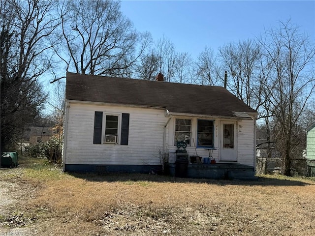 view of front of house with a chimney and a front lawn