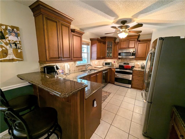 kitchen with appliances with stainless steel finishes, kitchen peninsula, and a kitchen breakfast bar