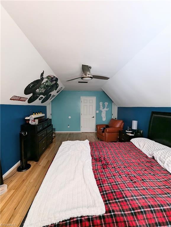 bedroom with vaulted ceiling, hardwood / wood-style flooring, and ceiling fan