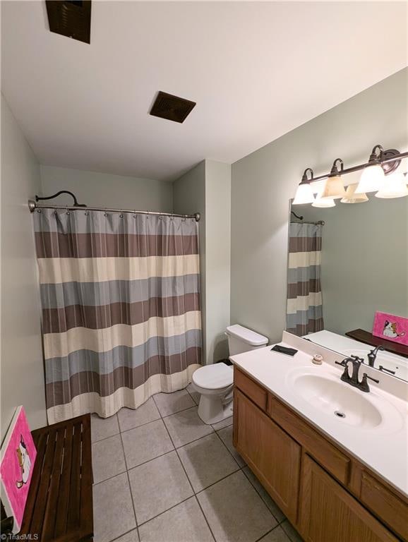 bathroom featuring walk in shower, vanity, toilet, and tile patterned floors