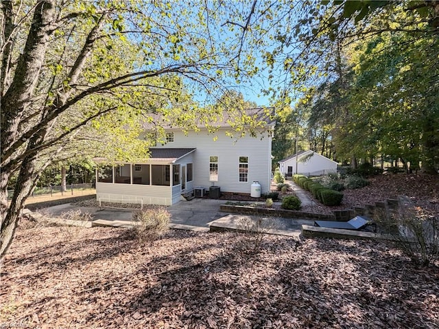 back of property with a sunroom and a patio area