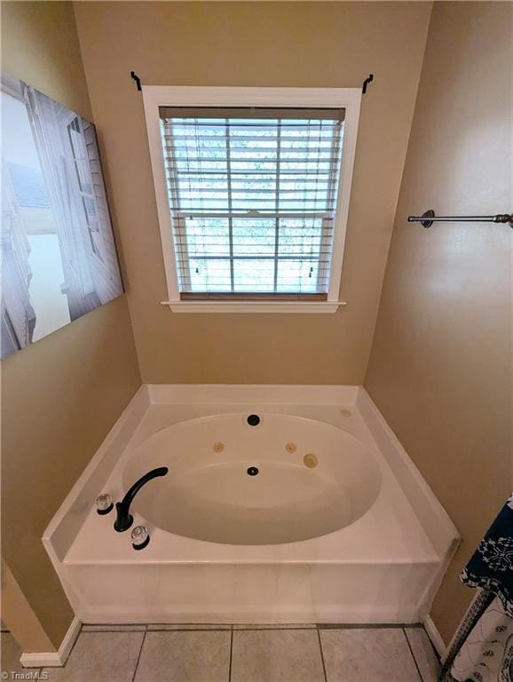 bathroom with a tub to relax in and tile patterned floors