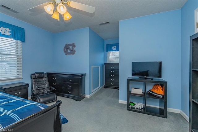 carpeted bedroom featuring a textured ceiling and ceiling fan