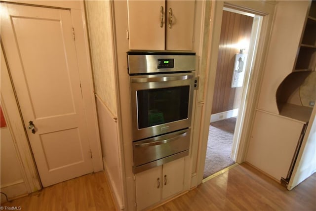 kitchen with oven and light hardwood / wood-style floors