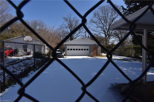 view of snowy exterior featuring an outbuilding and a garage