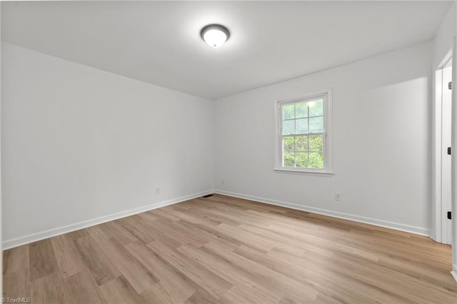 empty room with light wood-style floors and baseboards
