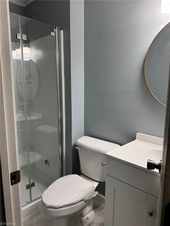 bathroom with vanity, toilet, and a shower with shower door