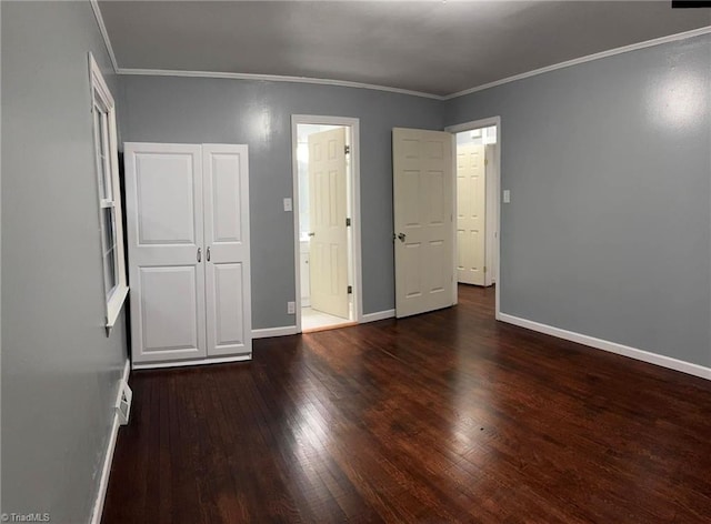 unfurnished bedroom featuring crown molding, a closet, and dark hardwood / wood-style floors