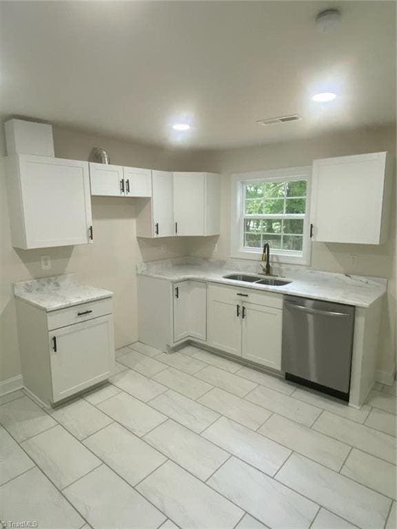 820 Broad Ave, Greensboro, NC 27406 - kitchen with stainless steel dishwasher, a sink, white cabinetry, and light countertops