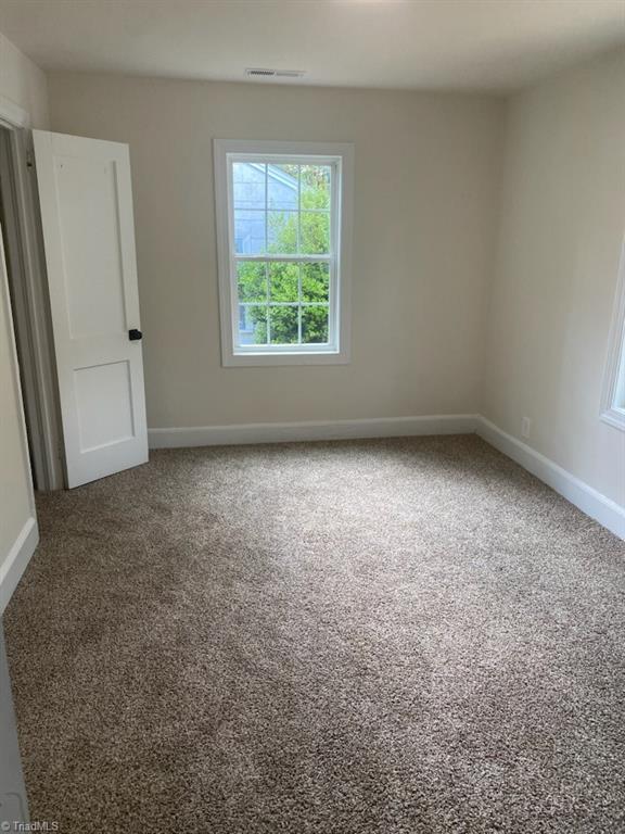 820 Broad Ave, Greensboro, NC 27406 - carpeted spare room with baseboards and visible vents