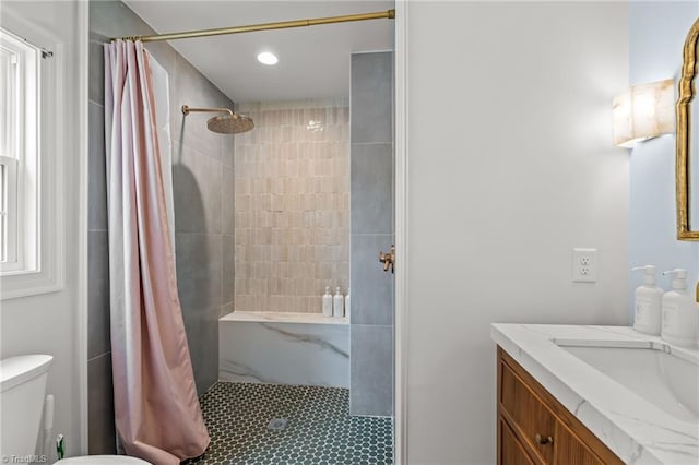 bathroom featuring tiled shower, vanity, and toilet