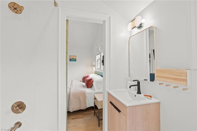 full bathroom featuring wood finished floors, vanity, and ensuite bathroom