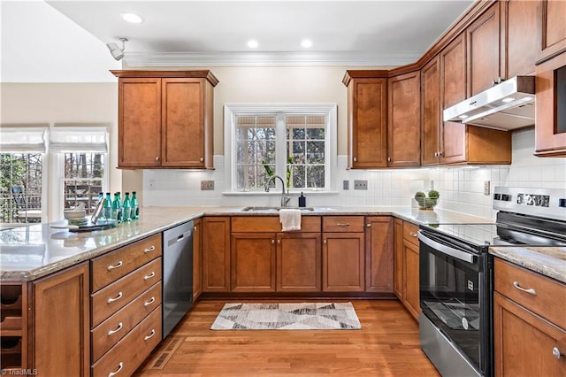 kitchen with sink, backsplash, stainless steel appliances, light stone counters, and light wood-type flooring