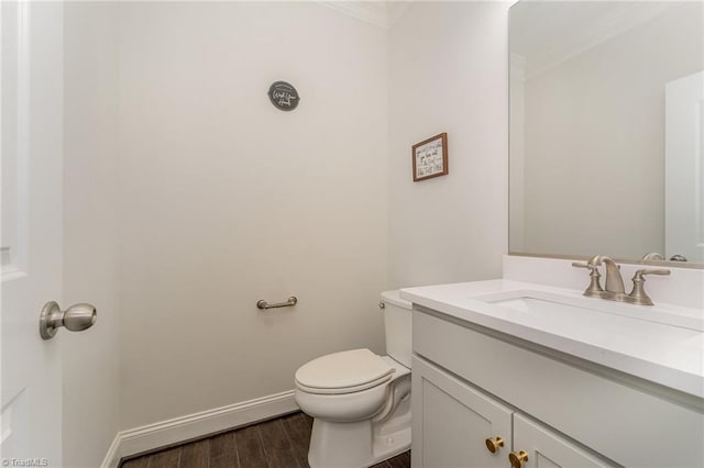 bathroom with vanity, toilet, and crown molding