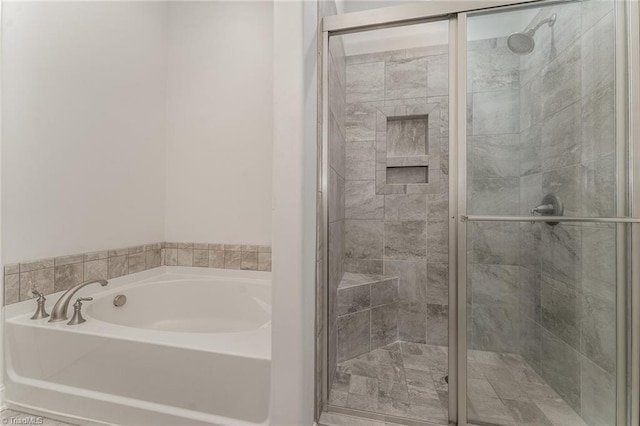 bathroom featuring shower with separate bathtub