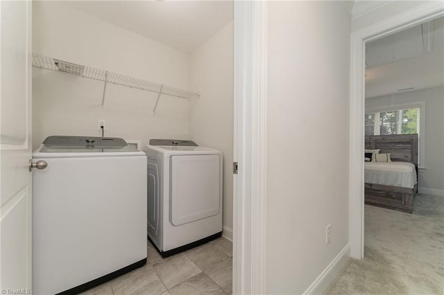 washroom with separate washer and dryer and light colored carpet